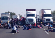 Miembros de caravana migrante acusan redadas del INM Protestaron acostándose sobre la carretera para obstruir el paso de vehículos. Foto: Alejandro Mendoza