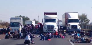 Miembros de caravana migrante acusan redadas del INM Protestaron acostándose sobre la carretera para obstruir el paso de vehículos. Foto: Alejandro Mendoza