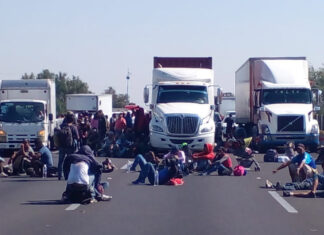 Miembros de caravana migrante acusan redadas del INM Protestaron acostándose sobre la carretera para obstruir el paso de vehículos. Foto: Alejandro Mendoza